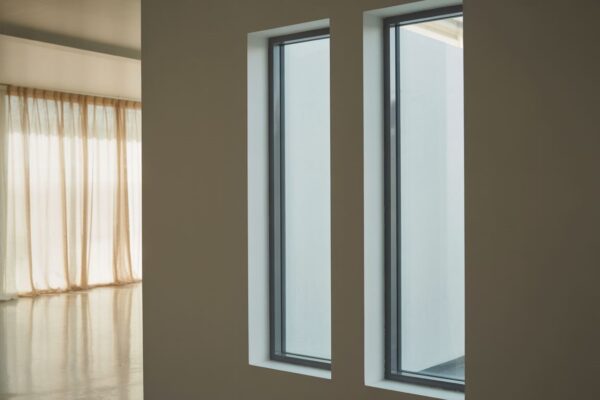 Jak efektywnie zaaranżować wnętrze z dwoma oknami na jednej ścianie? nowoczesne okna w jasnym pokoju